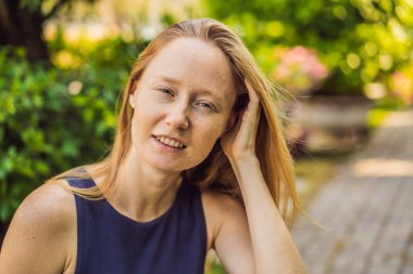 Cildimi seviyorum. Çilleri, benleri, yaraları ve yüz kırışıklıkları olan genç bir kadın cildini seviyor, hayattan zevk alıyor ve güzel bir parkta yürüyor.