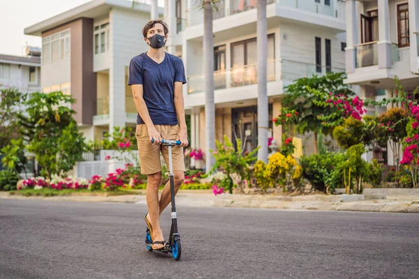 Man met medisch masker en berijdend op een scooter Coronavirus pandemie Covid-19. Sport, Actief leven in quarantaine chirurgische sterilisatie gezichtsmasker bescherming. Buitenteelt in Corona — Stockfoto