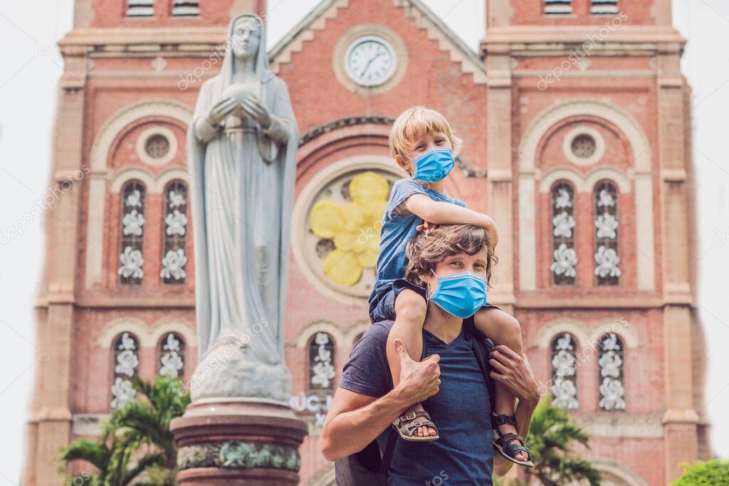 Father and son in medical mask in the background Notre dame de Saigon Cathedral, build in 1883 in Ho Chi Minh city, Vietnam Tourists fear the 2019-ncov virus. Medical masked tourists