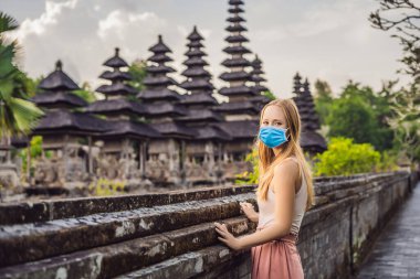 Mengwi 'deki geleneksel Hint Tapınağı Taman Ayun' da tıbbi maskeli genç bayan turist. Bali, Endonezya Turistleri 2019 ncov virüsünden korkuyorlar. Tıbbi maskeli turistler