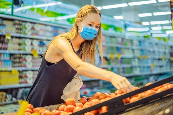 Женщина выбирает помидоры в супермаркете без пластикового пакета. Многоразовая сумка для покупки овощей. Концепция нулевых отходов — стоковое фото