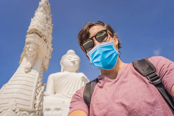 Man tourist in medical mask on background of Big Buddha statue Was built on a high hilltop of Phuket Thailand Can be seen from a distance Tourists fear the 2019-ncov virus. Medical masked tourists — Stock Photo, Image