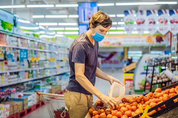 De mens kiest tomaten in een supermarkt zonder een plastic zak te gebruiken. Herbruikbare tas voor het kopen van groenten. Nul afvalconcept — Stockfoto