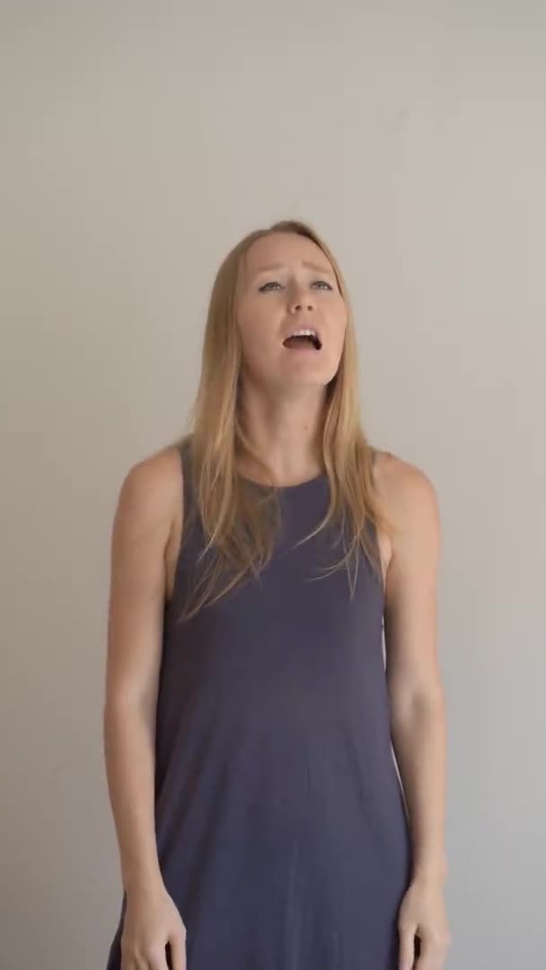 Vertical video. A young woman sneezes properly. She sneezes into her elbow — Stock Video