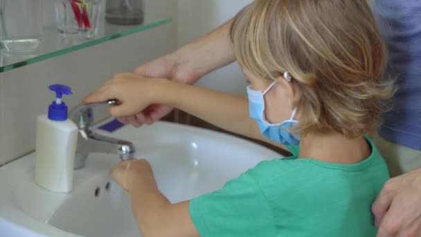 Un uomo e suo figlio si lavano accuratamente le mani con un sapone liquido, che li aiuta contro l'infezione da COVID-19. Igiene delle mani. Concetto di autoisolamento — Video Stock