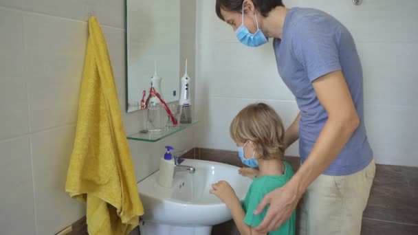 Un uomo e suo figlio si lavano accuratamente le mani con un sapone liquido, che li aiuta contro l'infezione da COVID-19. Igiene delle mani. Concetto di autoisolamento — Video Stock