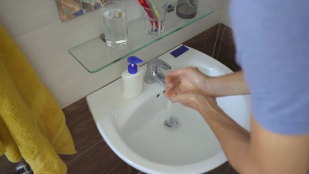 Mężczyzna ostrożnie myje ręce mydłem w płynie, co pomaga mu zapobiegać zakażeniu COVID-19. Koncepcja higieny rąk. Koncepcja samoizolacji — Wideo stockowe