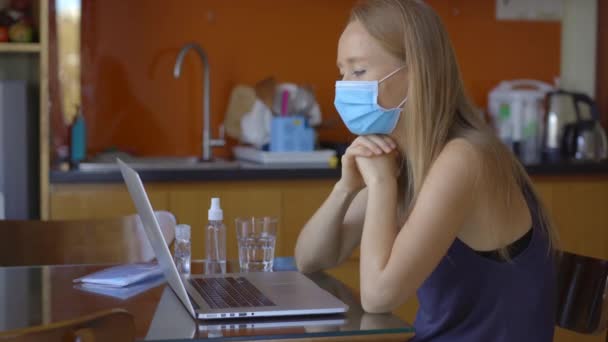 若い女性は、コロナウイルスの自己分離期に自宅に座っている間、ビデオ会議を通して話をします.社会的距離概念 — ストック動画