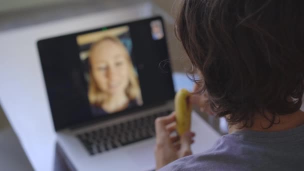 Egy férfi videokonferencián keresztül beszél, miközben otthon ül a koronavírus elszigeteltségének időszakában. Társadalmi távolság fogalma — Stock videók