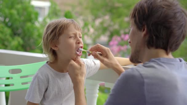 Чоловік чистить зуби своєму маленькому синові. Концепція догляду за зубами — стокове відео