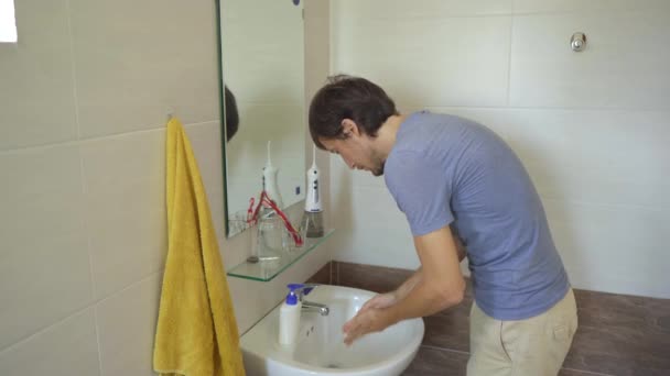 Een man wast zorgvuldig zijn handen met een vloeibare zeep, die hem helpt tegen COVID-19 infectie. Handhygiëne concept. Zelfisolatieconcept — Stockvideo