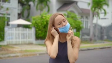 Genç bir kadın tıbbi maske takıyor. O bir caddede duruyor. Sosyal uzaklık kavramı. Dezenfeksiyon kavramı