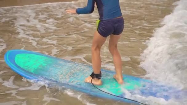 Surf instructor teaches little boy how to surf. Slowmotion shot — Stock Video
