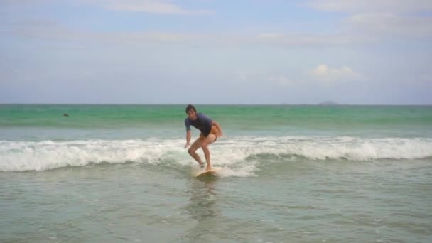 Een jongeman leert surfen. Langzame schot — Stockvideo