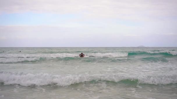 Молодой человек учится серфингу. Слоумоушн — стоковое видео