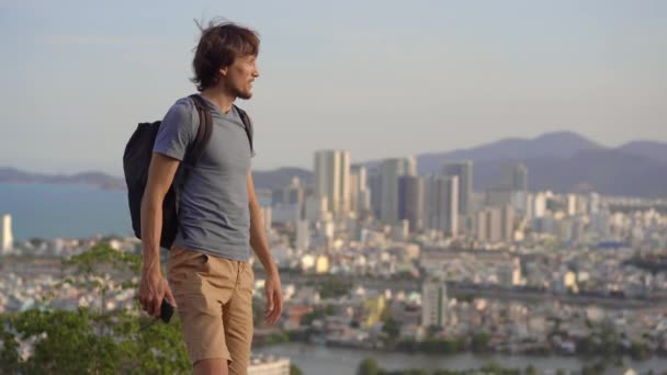 A young man tourist visits the miuntaing overlooking the Nha Trang city, a famous tourist destination in Vietnam — Stock Video