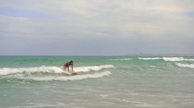 Genç bir adam sörf yapmayı öğrenir.