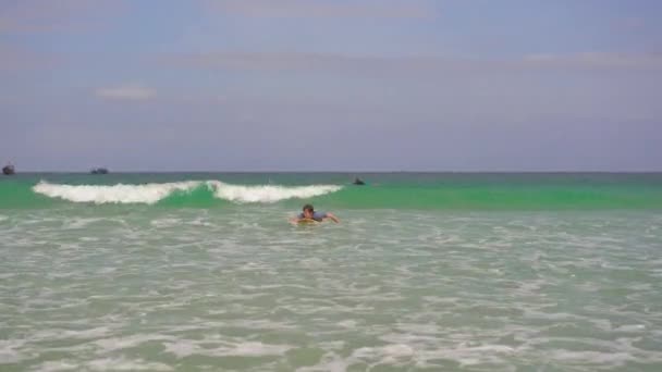 Um jovem aprende a surfar — Vídeo de Stock
