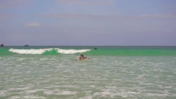 A young man learns how to surf — Stock Video