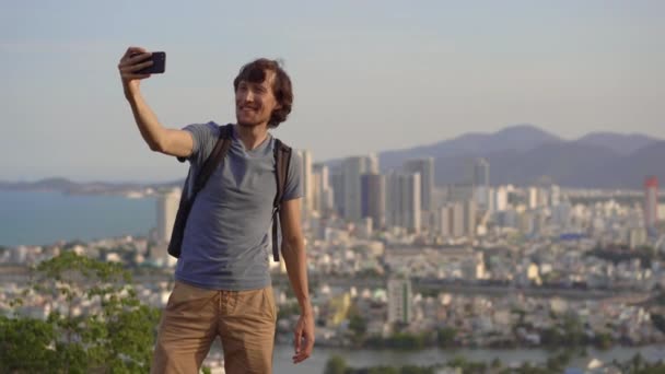 Genç bir turist, Vietnam 'da ünlü bir turizm merkezi olan Nha Trang şehrine bakan dağda selfie çekiyor. — Stok video