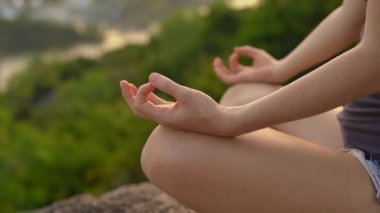 Genç bir kadın büyük bir şehrin tepesindeki bir dağda meditasyon yapıyor. Büyük bir şehirde iç huzur kavramı