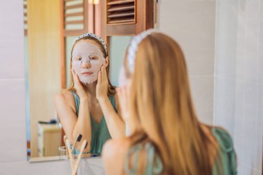 Yüz maskesi takan kızıl saçlı genç bir kadın. Güzellik ve Deri Bakımı Konsepti