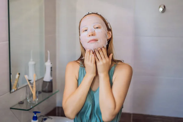 Jeune femme rousse faisant une feuille de masque facial. Concept Beauté et Soins de la peau — Photo