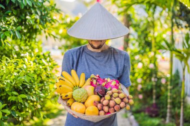 Vietnam şapkasındaki çeşitli meyveler. Vietnam şapkalı adam.
