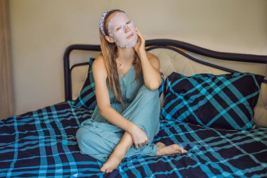 Yüz maskesi takan kızıl saçlı genç bir kadın. Güzellik ve Deri Bakımı Konsepti