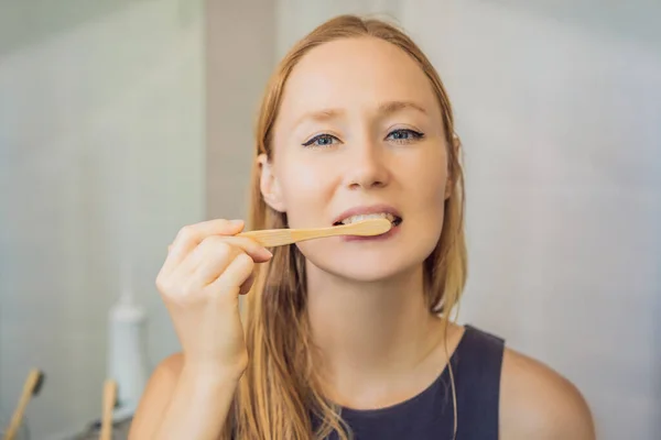 Young and caucasian woman brushing her teeth with a bamboo toothbrush — Stock Photo, Image