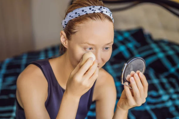 Sorridente donna bruna felice facendo il trucco a letto al mattino — Foto Stock