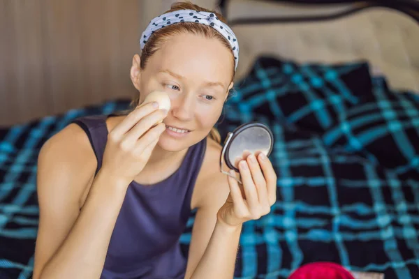 Uśmiechnięta szczęśliwa brunetka robi makijaż w łóżku o poranku — Zdjęcie stockowe