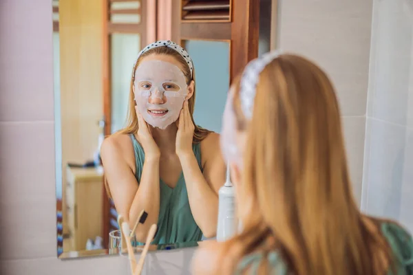 Joven mujer pelirroja haciendo mascarilla facial. Concepto de belleza y cuidado de la piel — Foto de Stock