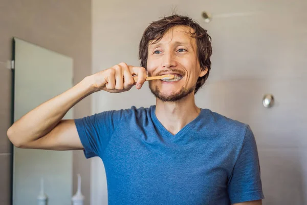 Személyi higiénia. A boldog kaukázusi fiatalember bambusz fogkefét hordoz, elégedett az egészséges életmóddal. Reggeli rutin. Zéró hulladék — Stock Fotó