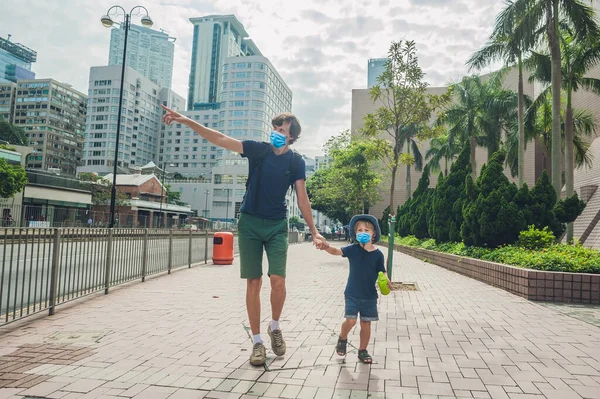 Πατέρας και γιος περπατούν στο Χονγκ Κονγκ. Ταξιδεύοντας με τα παιδιά έννοια Οι τουρίστες φοβούνται τον ιό 2019-ncov. Ιατρικοί μασκοφόροι τουρίστες — Φωτογραφία Αρχείου