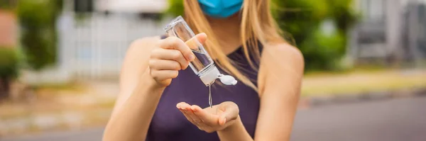 Woman in a small town in a medical mask uses a sanitizer because of a coronovirus epidemic BANNER, LONG FORMAT — Stock Photo, Image