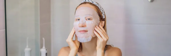 Jeune femme rousse faisant une feuille de masque facial. Concept beauté et soin de la peau BANNER, FORMAT LONG — Photo