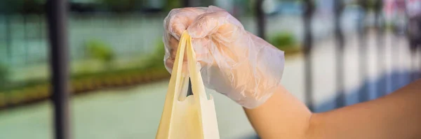Mulher mãos em luvas de proteção médica segurar pacote com compras BANNER, LONG FORMAT — Fotografia de Stock