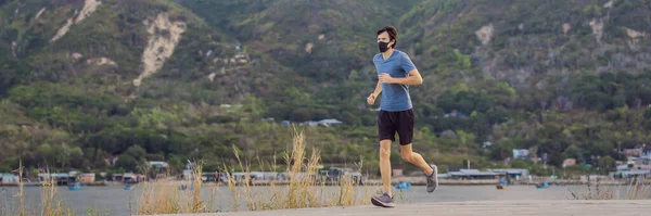 Corredor con máscara médica, pandemia de Coronavirus Covid-19. Deporte, vida activa en la cuarentena quirúrgica esterilización de la máscara facial de protección. Carrera al aire libre en pista de atletismo en Corona Brote BANNER, LONG — Foto de Stock