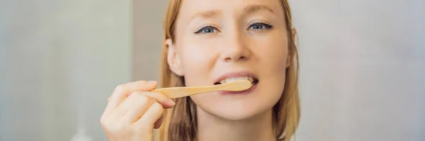 Mujer joven y caucásica cepillándose los dientes con un cepillo de dientes de bambú BANNER, FORMATO LARGO — Foto de Stock