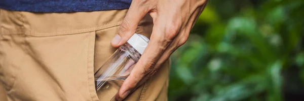 Man put a hand sanitizer gel into his trouser pocket when he is going to go outside during corovid -19 outbreak crisis, take care of personal health BANNER, LONG FORMAT — Stock Photo, Image