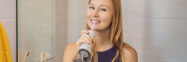 Egy nő szájon át történő öntözést használ a fürdőszobában BANNER, LONG FORMAT — Stock Fotó