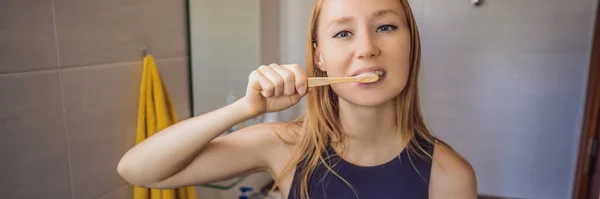 Mujer joven y caucásica cepillándose los dientes con un cepillo de dientes de bambú BANNER, FORMATO LARGO — Foto de Stock