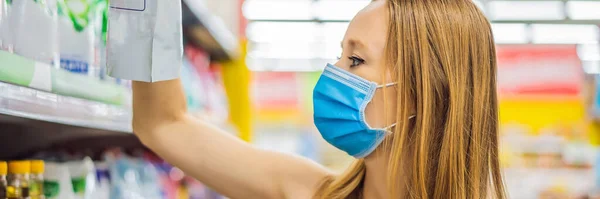 Тревожная женщина носит медицинскую маску против коронавируса во время покупок в супермаркете или магазине - здоровье, безопасность и пандемия - молодая женщина в защитной маске и запасах пищи — стоковое фото