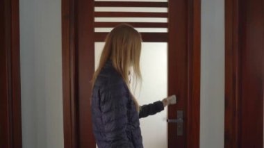 Bir kadın elini korumak için peçete kullanarak kapıyı açar. Koronavirüs salgını sırasında düzgün davranışlar. Hastalık önleme kavramı