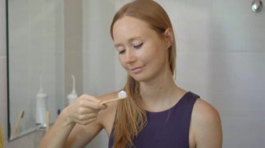 Genç bir kadın bambu ağacından yapılmış bir fırçayla dişlerini fırçalar. Sıfır atık. Biyolojik çözünebilir ürünler konsepti