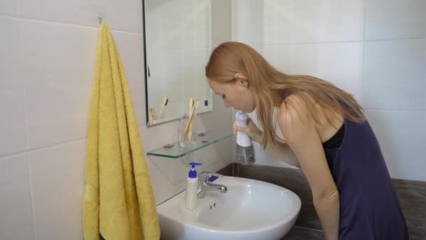 Une jeune femme se nettoie les dents à l'aide d'un arrosoir dentaire portatif à flotteur d'eau. Concept de soins des dents — Video