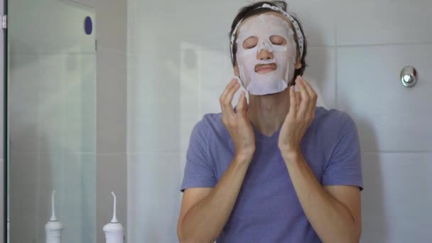 Mladý muž si nasadí kosmetickou masku. Koncept péče o pleť — Stock video