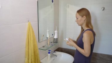 Genç bir kadın bambu ağacından yapılmış bir fırçayla dişlerini fırçalar. Sıfır atık. Biyolojik çözünebilir ürünler konsepti