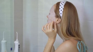Genç bir kadın kozmetik maske takıyor. Cilt bakımı kavramı